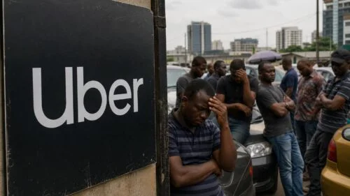A group of riders waiting near a car in a Nigerian street scene, with an Uber sign in the foreground